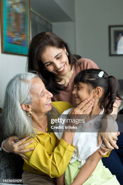 happy woman with grandmother embracing granddaughter - indian mother and daughter stockfoto's en -beelden