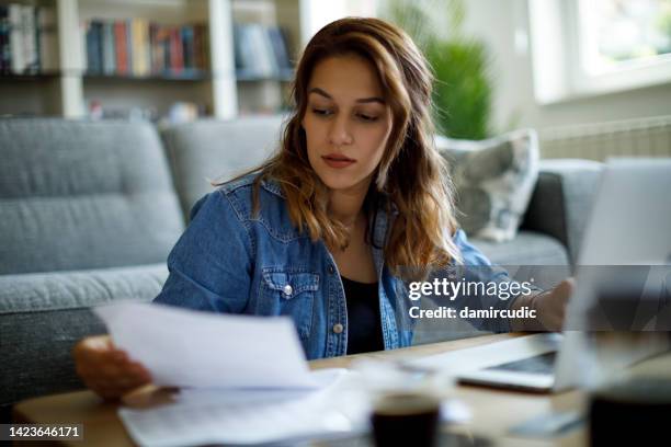 woman calculating finances at home - fee stock pictures, royalty-free photos & images