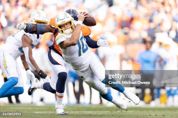 Justin Herbert of the Los Angeles Chargers is sacked by Stephen Weatherly of the Denver Broncos during the first half of an NFL football game at...