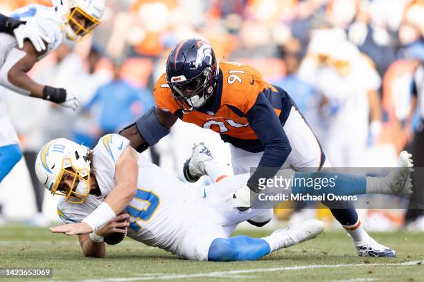 Justin Herbert of the Los Angeles Chargers is sacked by Stephen Weatherly of the Denver Broncos during the first half of an NFL football game at...