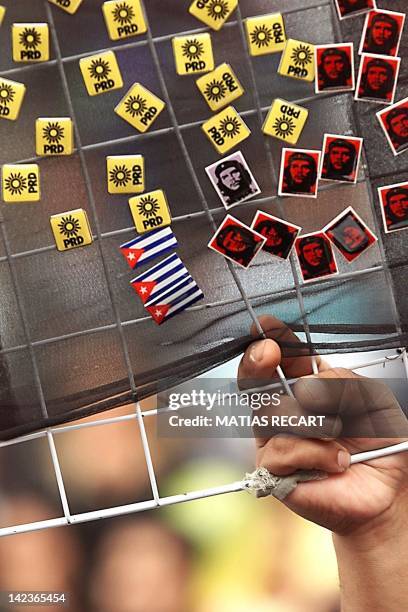 Vender sells buttons bearing the flag of Cuba, the image of "Che" and the flag of the Party for the Democratic Revolution , 17 September, 1999. The...