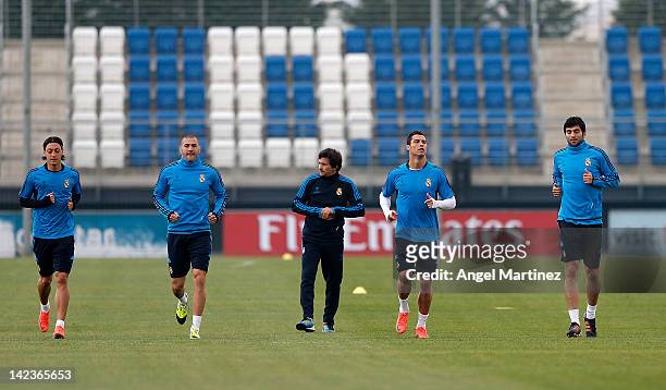 Mesut Ozil, Karim Benzema, assistant coach Rui Faria, Cristiano Ronaldo and Raul Albiol of Real Madrid warm up during a training session ahead of the...