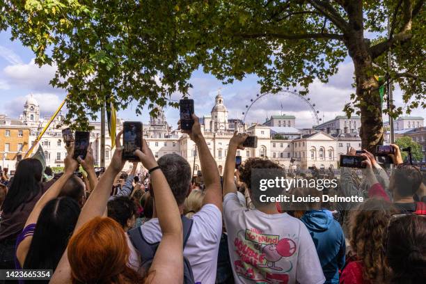 Members of the public photograph the cortege carrying the coffin of Queen Elizabeth II on September 14, 2022 in London, England. Queen Elizabeth II's...