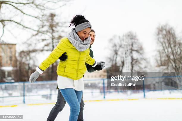 young adult couple ice skating - couple skating stock pictures, royalty-free photos & images