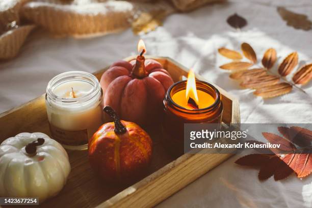 wooden tray with atmospheric candles and aututmn fall leaves on white bed. - november fotografías e imágenes de stock