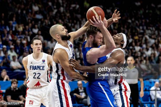 Nicolo Melli of Italy is blocked by Evan Fournier and Guerschon Yabusele of France during the FIBA EuroBasket 2022 quarterfinal match between France...