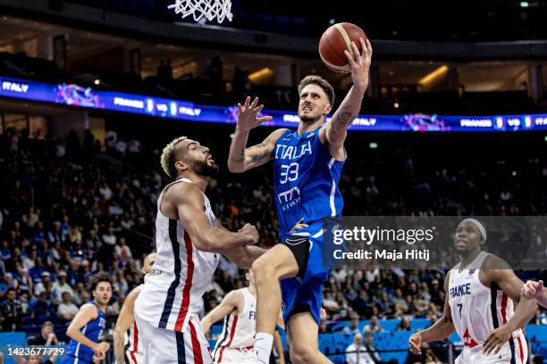 Achille Polonara of Italy jumps next to Rudy Gobert of France during the FIBA EuroBasket 2022 quarterfinal match between France v Italy at EuroBasket...