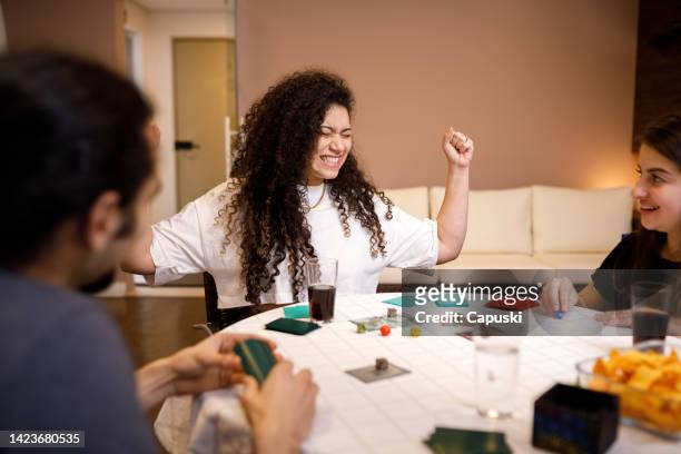 curly haired girl celebrating victory on the game - game night leisure activity stock pictures, royalty-free photos & images