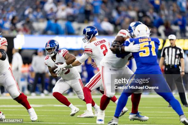 Mike Glennon of the New York Giants hands off to Elijhaa Penny of the New York Giants during an NFL football game against the Los Angeles Chargers at...