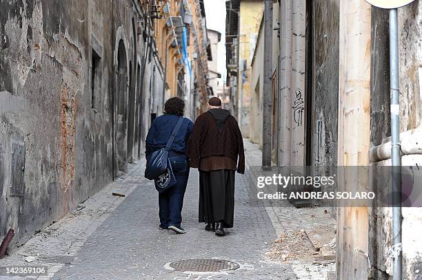 Franciscan friar walks on April 2, 2012 near the 'red zone' closed to public, in the historic area of L'Aquila devastated three years ago by an...