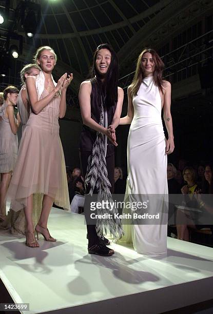 Designer Vera Wang is applauded by her models at the close of her Spring/Summer 2003 Collection fashion show at the New York Public Library during...