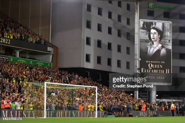 Norwich City fans sing the national anthem as a tribute to Her Majesty Queen Elizabeth II, who died at Balmoral Castle on September 8, 2022 prior to...