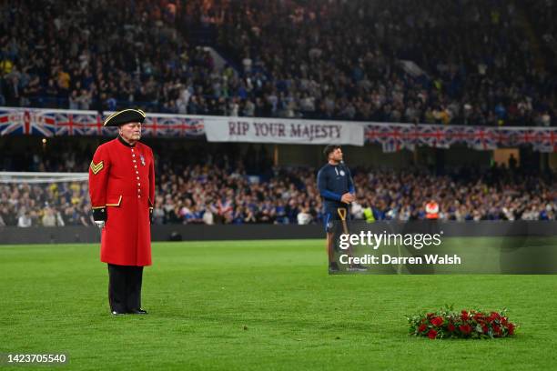 Chelsea pensioner stands by a wreath as a tribute to Her Majesty Queen Elizabeth II, who passed away at Balmoral Castle on September 8, 2022 prior to...