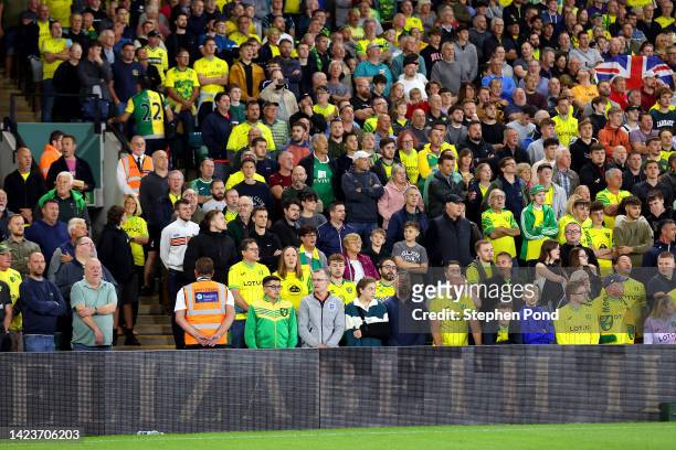 Norwich City fans sing the national anthem as a tribute to Her Majesty Queen Elizabeth II, who died at Balmoral Castle on September 8, 2022 prior to...