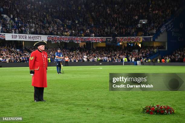 Chelsea pensioner stands by a wreath as a tribute to Her Majesty Queen Elizabeth II, who passed away at Balmoral Castle on September 8, 2022 prior to...