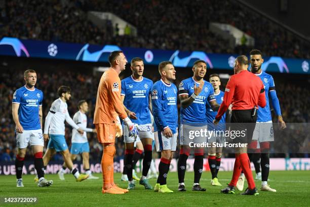 Players of Rangers FC contest the third penalty kick with Match Referee, Antonio Mateu Lahoz during the UEFA Champions League group A match between...
