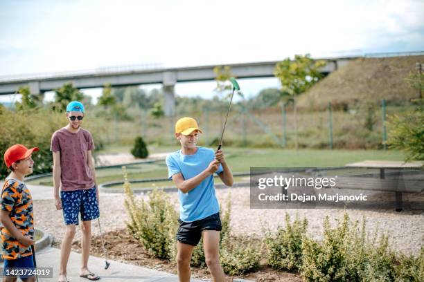 boys playing mini golf - putt stock pictures, royalty-free photos & images