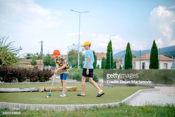 niños jugando al minigolf - miniature golf fotografías e imágenes de stock