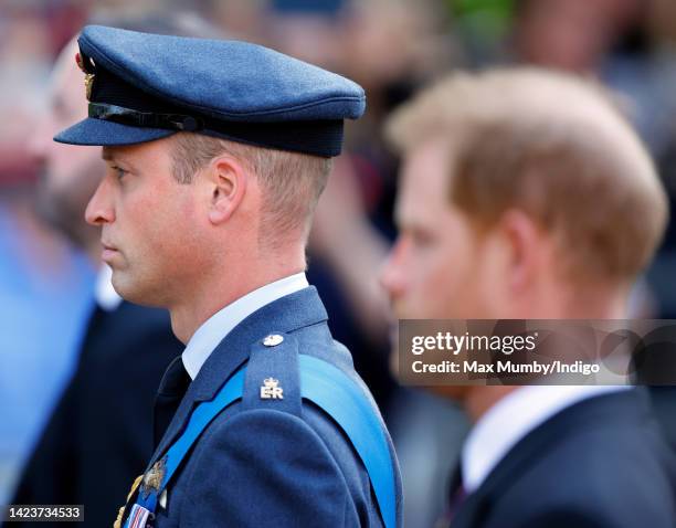 Prince William, Prince of Wales and Prince Harry, Duke of Sussex walk behind Queen Elizabeth II's coffin as it is transported on a gun carriage from...