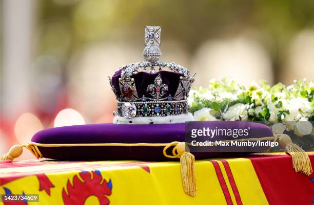 Queen Elizabeth II's coffin, draped in the Royal Standard and bearing the Imperial State Crown, is transported on a gun carriage from Buckingham...