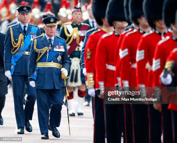 Prince William, Prince of Wales and King Charles III walk behind Queen Elizabeth II's coffin as it is transported on a gun carriage from Buckingham...