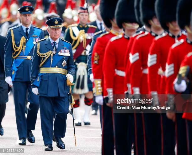 Prince William, Prince of Wales and King Charles III walk behind Queen Elizabeth II's coffin as it is transported on a gun carriage from Buckingham...