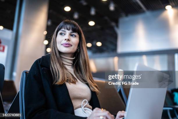 contemplative young woman using the laptop in the airport - patient journey stock pictures, royalty-free photos & images