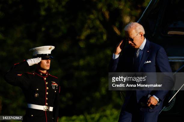 President Joe Biden raises his hand to salute as he walks off of Marine One after returning to the White House on September 14, 2022 in Washington,...