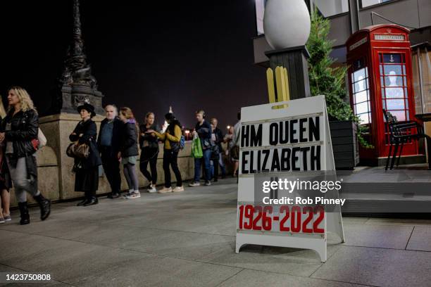 Sandwich board displaying the years of Queen Elizabeth II's life is seen on Southbank as tens of thousands join queues to see Queen Elizabeth II...