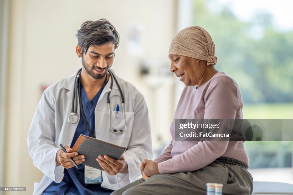 Onkologe diskutiert Medikamente mit einem älteren Patienten