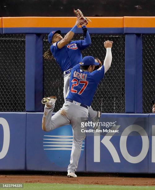 Michael Hermosillo of the Chicago Cubs collides with teammate Seiya Suzuki after making a catch in the ninth inning on a ball hit by Eduardo Escobar...