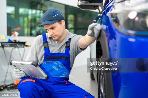 professional workers inspect the performance of tires and suspension performance of cars after setup and service on distance and keep the detail overall in an automotive service shop. he uses the digital computer and shows by digitization display. - coolant stockfoto's en -beelden