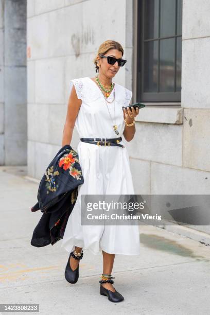 Guest wearing white dress, black belt outside Gabriela Hearst on September 13, 2022 in New York City.