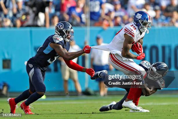 Kevin Byard of the Tennessee Titans and Roger McCreary of the Tennessee Titans tackle Kenny Golladay of the New York Giants during the game at Nissan...