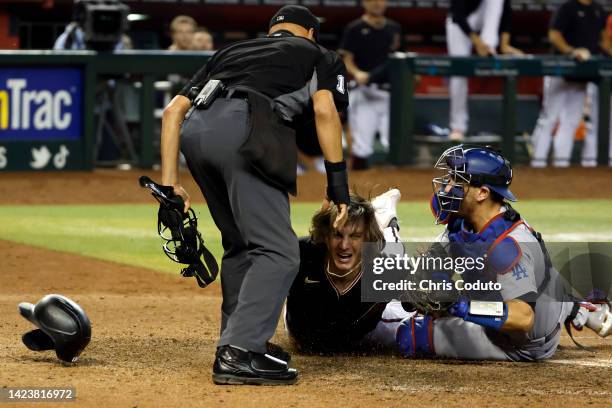 Jake McCarthy of the Arizona Diamondbacks is tagged out by Austin Barnes of the Los Angeles Dodgers while attempting to steal home during the bottom...