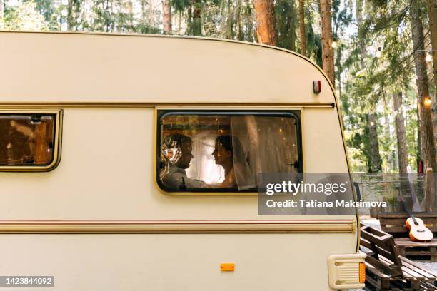a young couple in love in a camper trailer on a summer day. - russia travel stock pictures, royalty-free photos & images