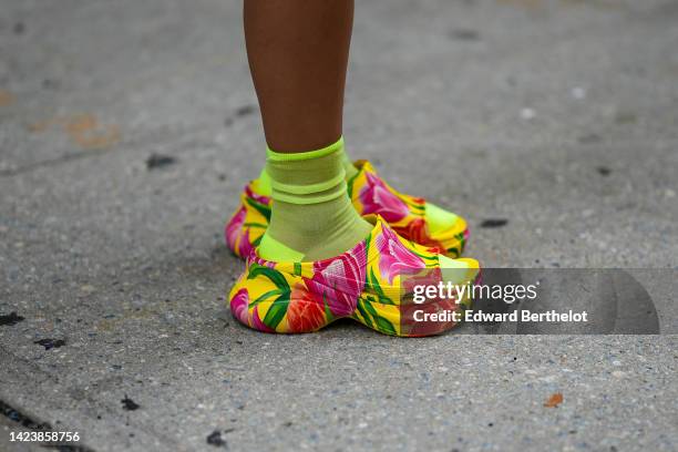 Guest wears neon yellow socks, yellow with red and pink flower painted pattern open toe cap / plastic mules , outside COS, during New York Fashion...