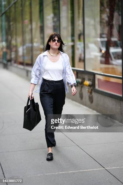 Guest wears black sunglasses, gold large chain necklaces, a white tank-top, a white shirt, black suit pants, a black shiny varnished leather...
