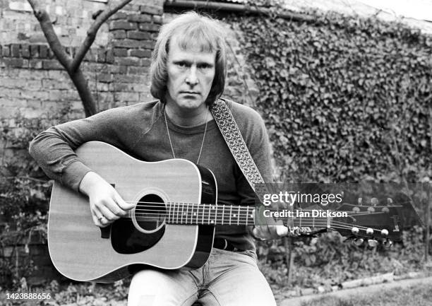 Dennis Waterman, portrait with acoustic guitar, London, 1975.