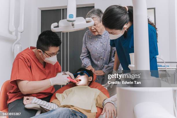 asian chinese grandmother accompany grandson visit dentist for dental routine checkup - root canal procedure stock pictures, royalty-free photos & images