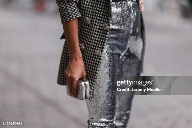 Denisa Palsha is seen wearing silver sequins Isabel Marant pants, houndstooth pattern Giuseppe di Morabito blazer jacket and silver clutch bag,...