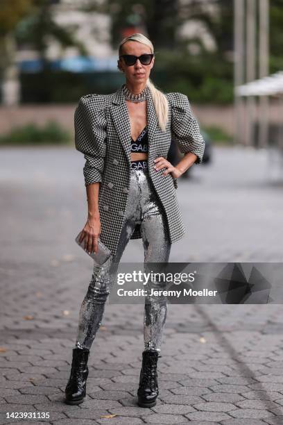 Denisa Palsha is seen wearing black Burberry shades, black silk bralette from Dolce Gabbana, silver sequins Isabel Marant pants, houndstooth pattern...