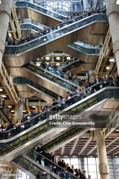 Employees and guests line the escalators in the atrium of the Lloyd's of London underwriting room during a remembrance ceremony honoring the life of...