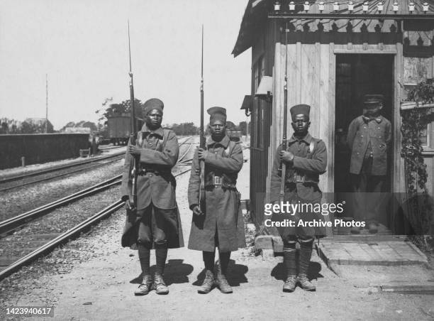 Three African soldiers from a unit of Bataillon Tirailleurs Sénégalais from the L'Infanterie Coloniale of the French Army present arms with their...