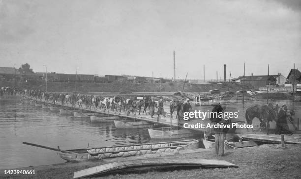Column of dismounted 1er Régiment de Spahis Algerien light cavalry attached to the 6eme Armée crossing a pontoon bridge over the River Oise at...