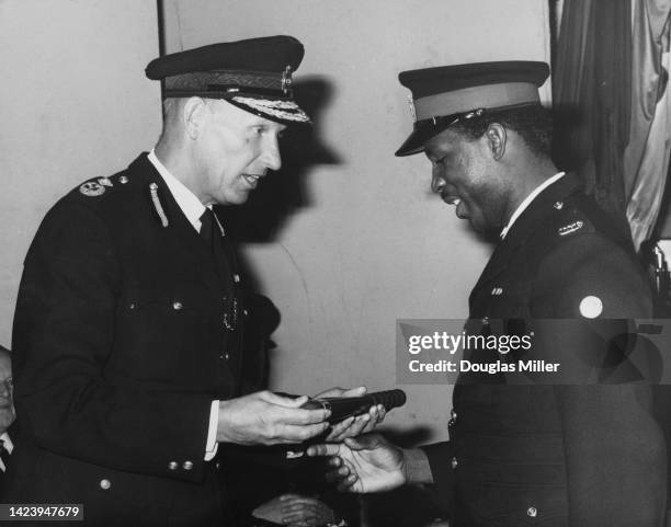 British Deputy Assistant Commissioner P J Collier presents the Baton of Honour to Jamaican police sergeant B H Milwood at the overseas students...