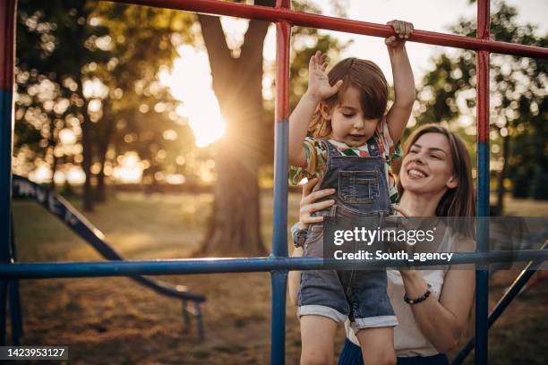 mother and daughter having fun together on playground - playground stock pictures, royalty-free photos & images