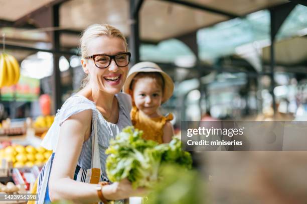 mutter und tochter kaufen salat auf dem grünen markt - lebensmittel einkauf stock-fotos und bilder