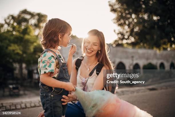 mother and daughter eating cotton candy - sharing chocolate stock pictures, royalty-free photos & images