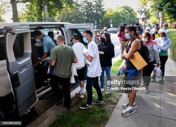 Migrants from Central and South America load into vans near the residence of US Vice President Kamala Harris after being dropped off on September 15,...